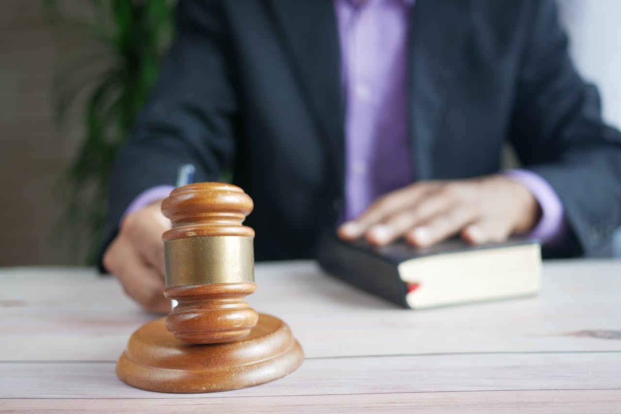 about-us-02 A wooden gavel and legal book represent justice in a court setting, emphasizing order and legal authority.